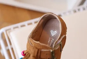 Macro detail van suède kinderschoen met kleurrijke kralen en binnenzool met hartprint