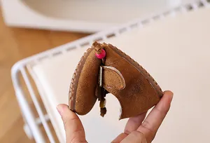 Detailopname van de flexibele rubberen zool van deze zachte bruine leren kinderschoen