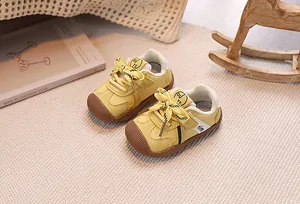 Detailed close-up of a yellow baby walker shoe with anti-collision toe and bow detail