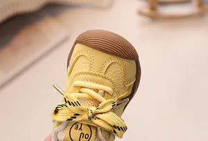Close-up of baby sneaker with lychee texture leather and brown rubber toe protection
