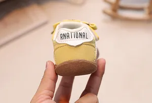 Detail of baby walking shoe showing the soft non-slip rubber sole and yellow suede upper