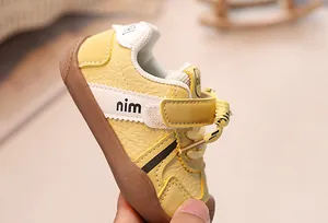 Detail of baby sneakers featuring yellow leather texture and durable rubber non-slip soft sole