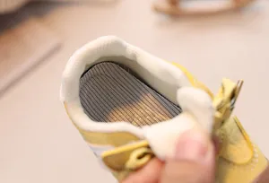 Close-up of baby sneakers showing thick padded heel support and breathable mesh insoles