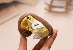 Macro view of flexible soft-sole baby walking shoes showing extreme flexibility and grip