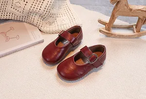 Macro detail of dark red leather Mary Jane shoes for girls with premium glossy finish