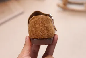 Vue détaillée d'une chaussure plate en daim marron pour enfant avec semelle antidérapante