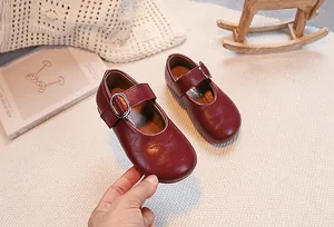 Detail of burgundy Mary Jane shoes for girls with silver buckle and textured leather