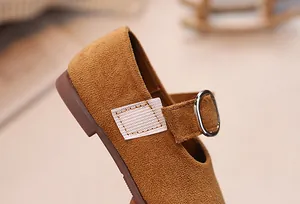 Détail de la chaussure en daim pour fille montrant la boucle en métal et la texture douce