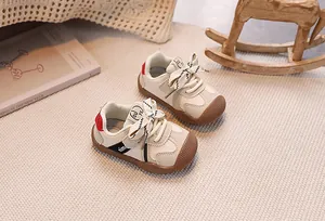 Detail of baby walking shoe with rubber toe cap and ribbon bow tie on cozy carpet