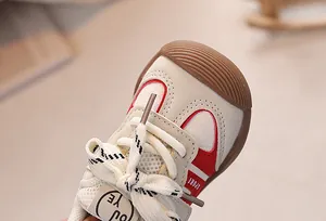 Detailed close-up of baby sneakers with litchi grain leather and anti-collision rubber toe