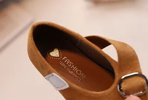 Détail de la semelle intérieure douce et du motif doré gaufré sur la chaussure en daim
