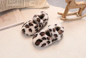 Close-up of plush leopard print baby shoes on a soft woven rug for winter warmth