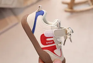 Close-up of beige baby sneakers with sport logo and non-slip rubber sole detail