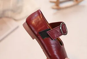 Detailed close-up of dark red Mary Jane shoes for girls with litchi grain faux leather