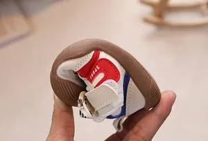 Detail showing the flexible soft rubber sole of toddler shoes being bent by hand