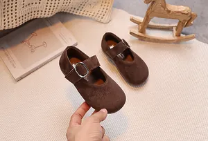 Détail de chaussures Mary Jane pour filles en daim marron foncé avec boucle argentée rétro