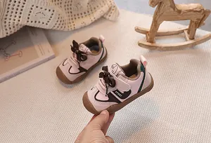 Detailed close-up of pink and brown baby walking shoes with non-slip rubber soles