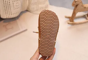 Close-up of baby snow boots featuring a brown non-slip rubber sole with wavy patterns