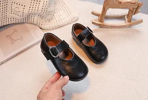 Detailed macro view of black PU leather Mary Jane shoes with silver metal buckle strap