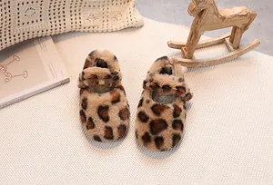 Detail of baby leopard print faux fur shoes with buckle strap on a cozy woven blanket