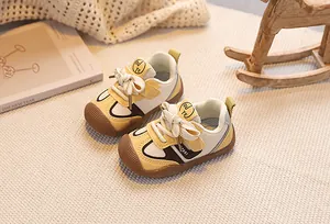 Detail of toddler sneakers featuring protective rubber toe cap and soft leather panels