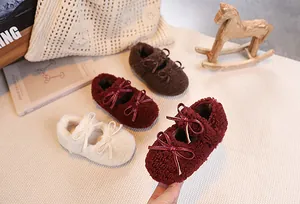 Detail of plush baby Mary Jane shoes with double bows in burgundy, brown and cream white
