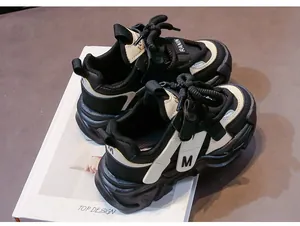 Detailansicht der Kinder-Sneaker mit dicker Sohle, M-Logo und schwarz-beigem Mesh-Gewebe