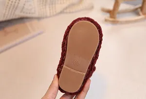 Detail view of anti-slip rubber sole with size 22 on red plush baby winter shoes
