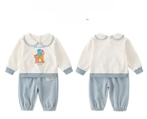 Detail of baby cotton two-piece set with cartoon bear print and blue trim accents