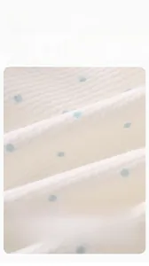 Macro shot of white and blue dot cotton waffle fabric showing soft texture for infants