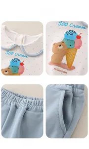 Detail view of cotton baby outfit showing Peter Pan collar and cartoon prints
