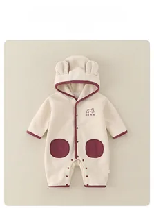 Détail de barboteuse bébé à capuche avec broderie ours et bordure rouge contrastée