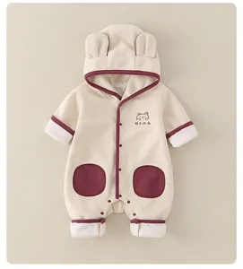 Détail de barboteuse bébé beige avec capuche à oreilles d'ours et boutons