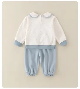 Detail of infant cotton set with blue polka dot Peter Pan collar top and blue trousers
