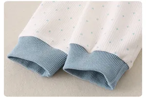 Macro shot of cotton baby sleeve showing blue polka dots and elastic ribbed cuffs