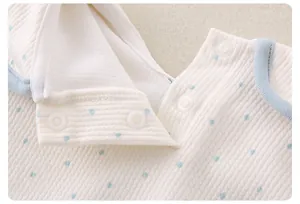 Detail of baby cotton top neckline featuring blue polka dots and snap button closure