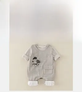Detailed close-up of a light grey baby overalls romper with a cute cartoon dog print