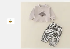 Détail d'un sweat en coton pour bébé avec imprimé chien et pantalon décontracté rayé