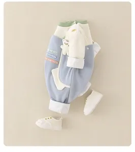 Dettaglio della tuta da neonato con tasca orsetto 3D e ricami color pastello