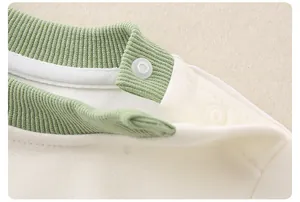 Dettaglio felpa neonato con scollatura a coste verde e bottoni a pressione sulla spalla