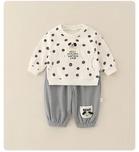 Dettaglio tuta per neonati in cotone con applique a cane e stampa testo Stay Foolish