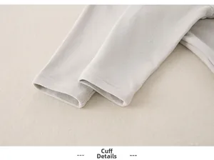 Detailed view of the smooth, ribbed cuff craftsmanship on baby cotton long-sleeve top