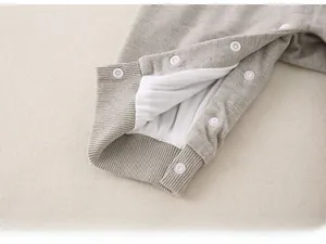 Detailed macro view of gray knitted baby romper with secure snap buttons and ribbed cuffs