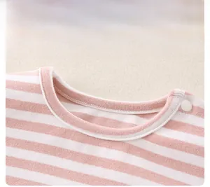 Close-up of pink striped cotton baby romper with round neckline and shoulder snap button