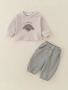 Ensemble bébé en coton pour le printemps avec haut abricot et pantalon rayé