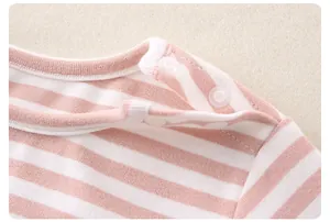 Close-up of pink striped cotton baby bodysuit with snap buttons on the shoulder