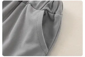 Dettaglio dei pantaloni in maglia grigia per neonati con elastico in vita e tasche laterali