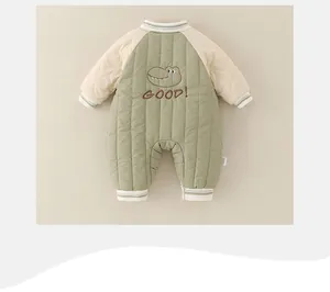 Detailweergave van babyrompertje met groene gewatteerde stof en schattig krokodillenborduur