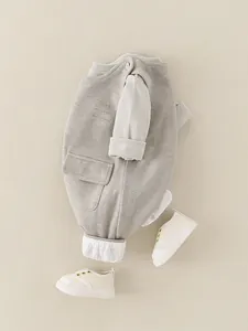 Infant autumn outfit with grey knit romper, cream long sleeve shirt and canvas shoes