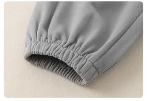 Dettaglio dei polsini elastici grigi in maglia di cotone per neonati con trama del tessuto
